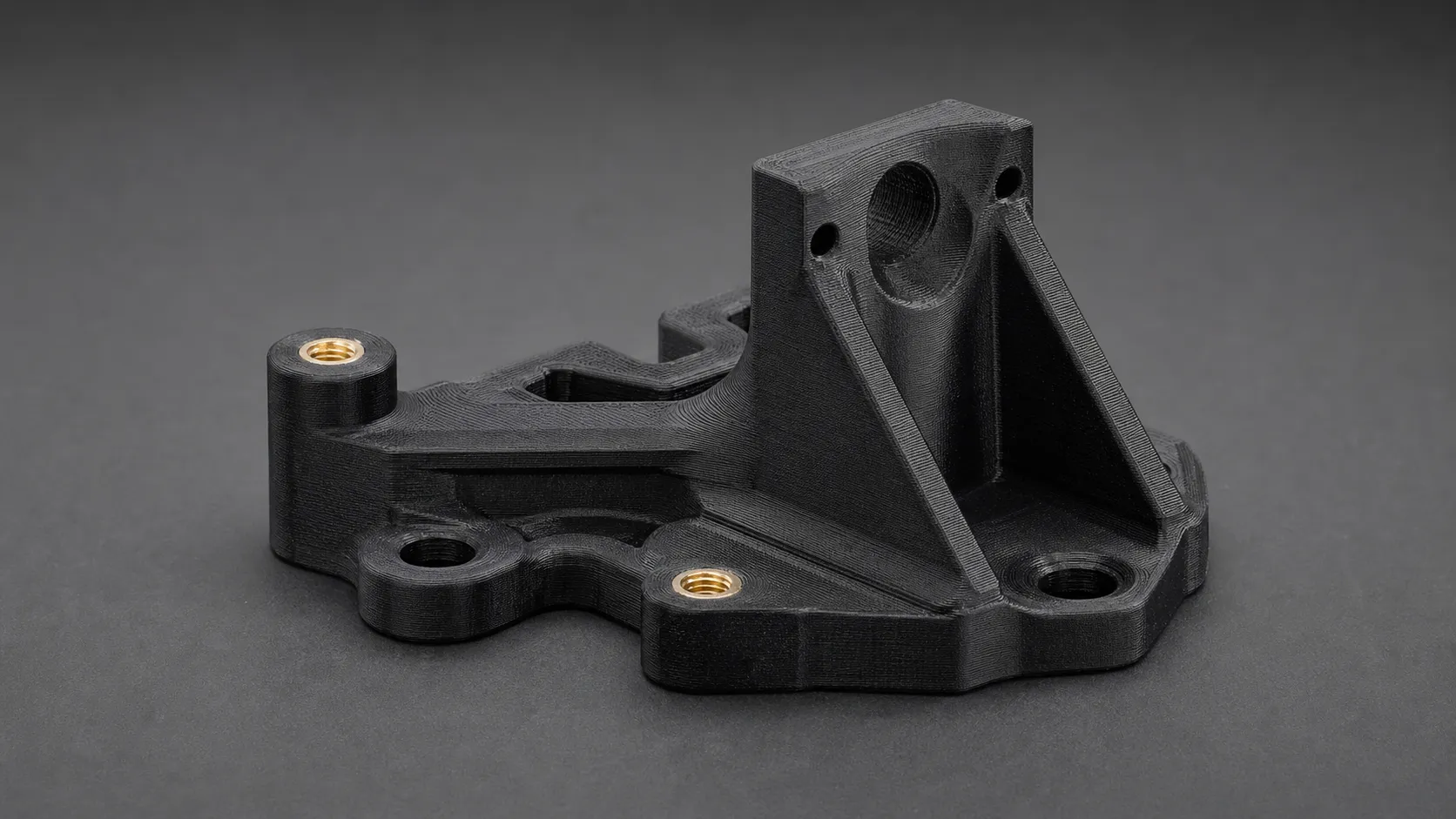 Support technique noir imprimé 3D en polyamide chargé carbone avec inserts laiton pour vissage
